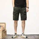 Person wearing green cargo shorts with a wooden crate and white wall in the background, Obroi