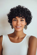 Woman with styled hair wearing a white top against a plain background, Obroi