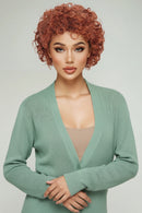 Woman with styled red hair wearing a green top against a light background, Obroi