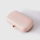 Pink clutch with a gold clasp on a light gray background, Obroi