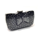 Black clutch bag with white polka dots and rhinestone accents on a white background, Obroi