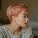 Woman with short pink hair wearing a gray sweater, Obroi