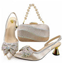 Pair of embellished high-heeled shoes with a matching clutch bag on a white background, Obroi