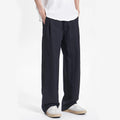 Person wearing black wide-leg pants and a white shirt on a white background, Obroi