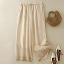 Beige pants with lace trim, a woven handbag, and white shoes on a light background, Obroi