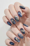 Hand with galaxy-themed nail art on a light background, Obroi