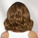 Close-up of a person with wavy brown hair on a plain background, Obroi