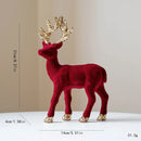 Red deer figurine with gold antlers and feet on a beige , Obroi