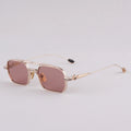 Sunglasses with gold frame and pink lenses on a light gray background, Obroi