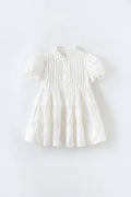 White dress with ruffled details on a light gray background, Obroi