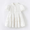 White dress with ruffled details on a light gray background, Obroi