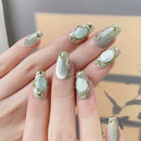 Nail art with decorative stones on a neutral background, Obroi