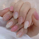 Close-up of a hand with pink and glittery nails on a white background Obroi
