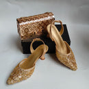 Gold glittery high-heeled shoes and a matching handbag on a white background, Obroi
