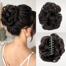 Black curly hair extension bun clip shown on a model from the back, with two additional views of the hairpiece on a light background, including one view showing the silver claw clip mechanism, Obroi
