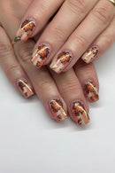 Nails with autumn leaf design on a white background, Obroi