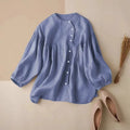 Blue blouse on a beige surface with pink shoes and dried plants, Obroi