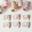 Floral nail art designs on a textured white surface, Obroi