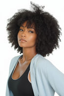 Woman with curly hair wearing a light blue jacket indoors, Obroi