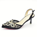 Black high-heeled shoe with decorative embellishments on a white background, Obroi
