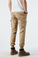 Person wearing beige cargo pants on a white background, Obroi