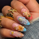 Close-up of a hand with intricately designed nails featuring sea-themed decorations, Obroi