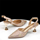 Pair of embellished high-heeled shoes on a white surface with a black background, Obroi