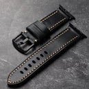 Obroi Black leather watch strap with gold stitching on a dark gray surface