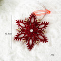 Red snowflake ornament with gold accents on a white background, Obroi