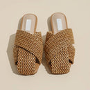 Pair of woven sandals on a beige background