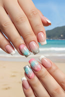 Nails with beach-themed design in front of a beach background, Obroi