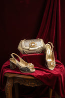 Gold and silver shoes and handbag on a red fabric background, Obroi