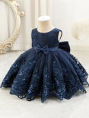 Navy blue lace dress with a large bow on a mannequin against a decorative background, Obroi