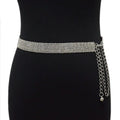 Silver belt with chain detail on a black dress against a white background, Obroi