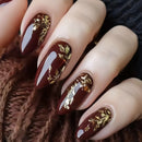 Nails with brown and gold design on a textured brown background, Obroi