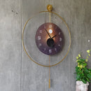 Decorative wall clock with gold frame and dark face on a concrete wall, Obroi