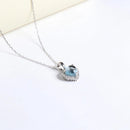 Heart-shaped pendant with blue gemstone on a white background, Obroi