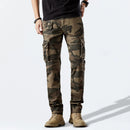 Person wearing camouflage cargo pants on a light gray background, Obroi