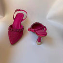 Pink high-heeled shoes with embellishments on a white background, Obroi