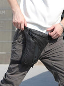 Person wearing dark gray pants with a black holster attached to the waist, Obroi