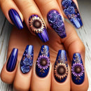 Nails with floral designs in blue, purple, and gold on a neutral background, Obroi