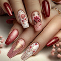 Nails with floral and heart designs in red, pink, and white on a neutral background, Obroi