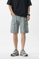 Person wearing gray cargo shorts on a white background, Obroi
