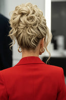 A blonde curly hairpiece shown worn on a woman's head from the back, alongside two close-up views of the hairpiece itself on a light background. The hairpiece is secured with a cream-colored claw clip, Obroi