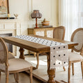 Dining room with wooden table and chairs, featuring a decorative table runner, Obroi