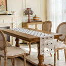 Dining room with wooden table and chairs, featuring a decorative table runner, Obroi