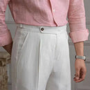 Person wearing a pink shirt and light gray pants with a blurred background, Obroi