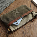 Brown leather pouch with a phone inside on a wooden surface, Obroi