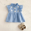 Blue dress with white floral embellishments on a light beige background