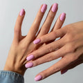Close-up of hands with pink nail polish on a neutral background, Obroi